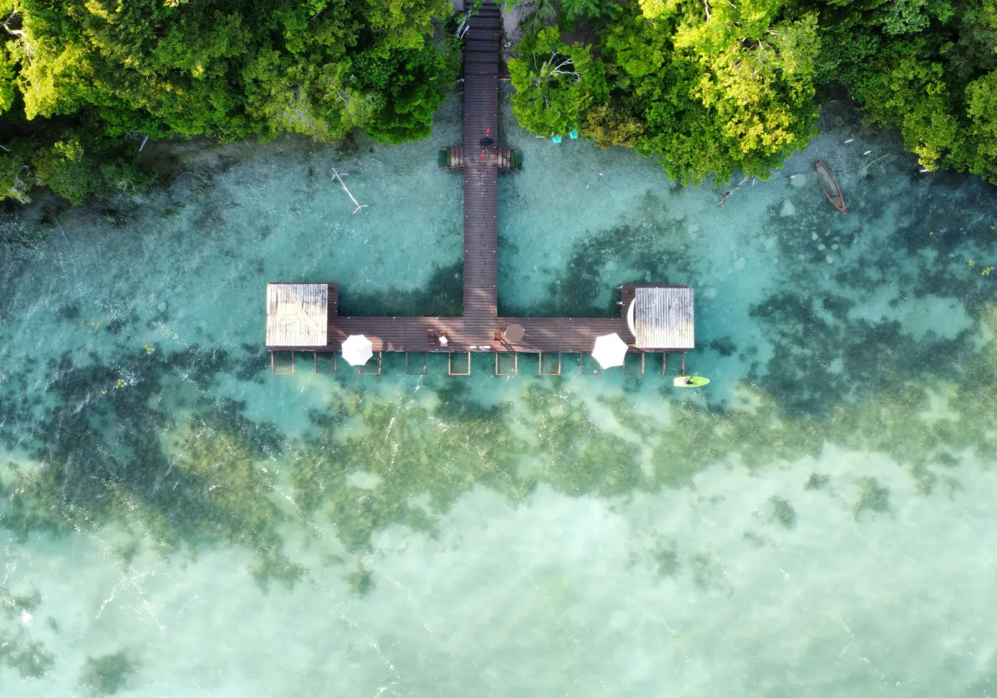 Aerial view of a wooden pier and the clear waters of Bacalar Lagoon